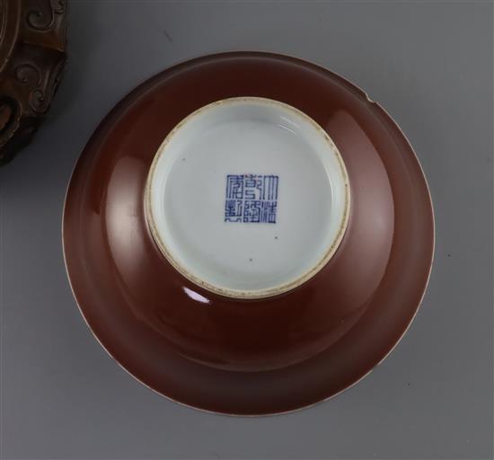 A Chinese copper red glazed bowl, Qianlong seal mark and of the period (1736-95), D. 18.2cm, small rim chips, wood stand